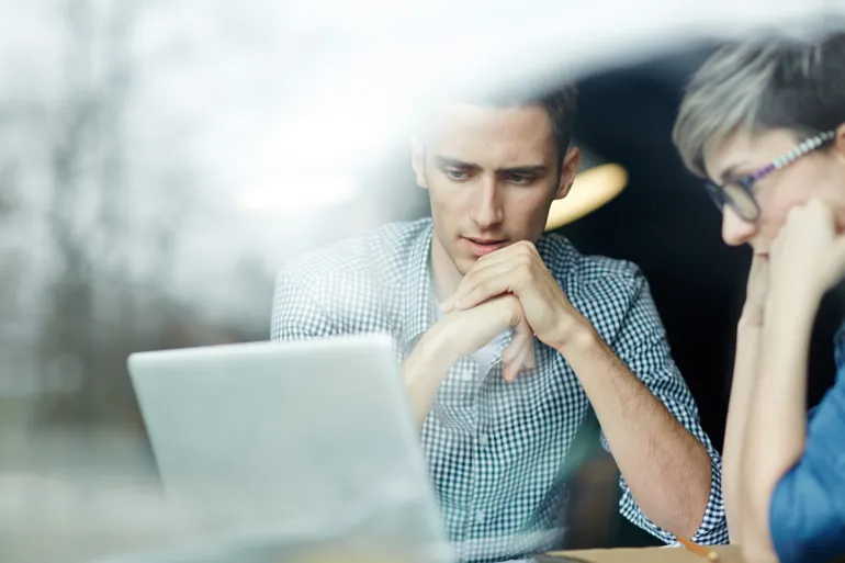 A man and a woman looking at a laptop