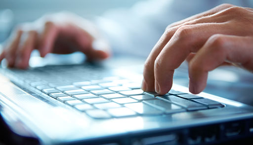 Nærbilde av hendene på et tastatur