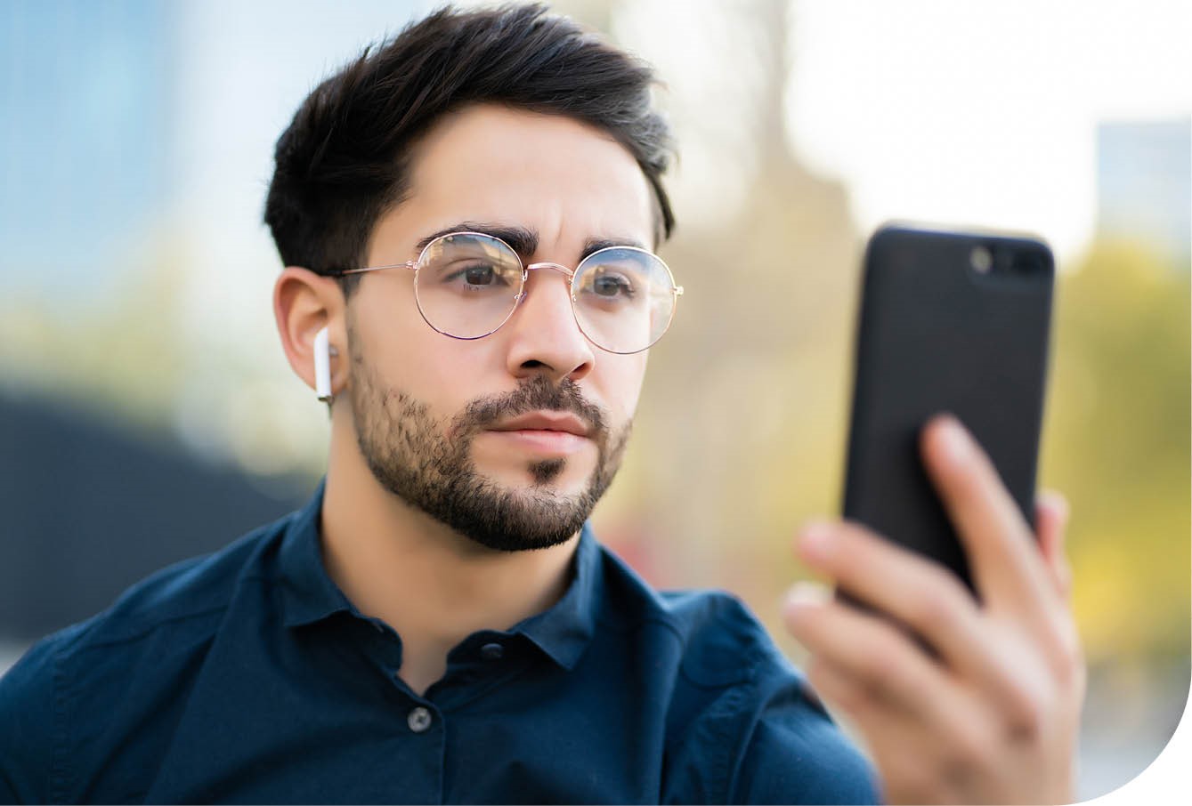 En mann logger inn på mobilen med ansiktsgjenkjenning