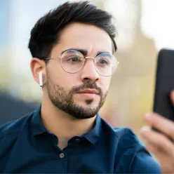 En mann logger inn på mobilen med ansiktsgjenkjenning