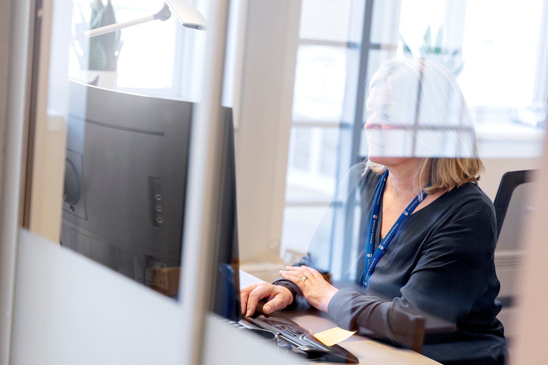 En kvinne sitter ved pc-skjerm