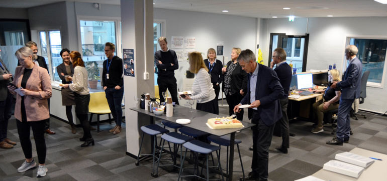 En gruppe mennesker som står rundt et bord med mat på