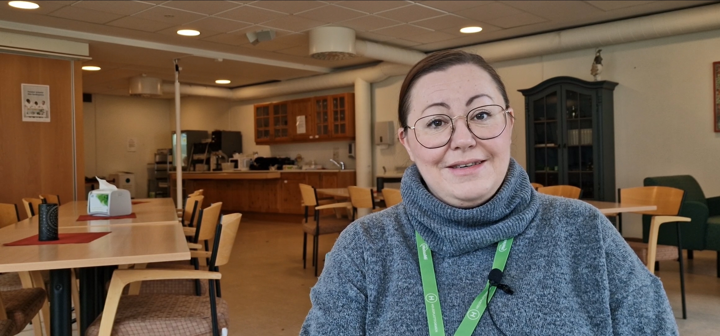 Kvinne med briller sitter i møterom