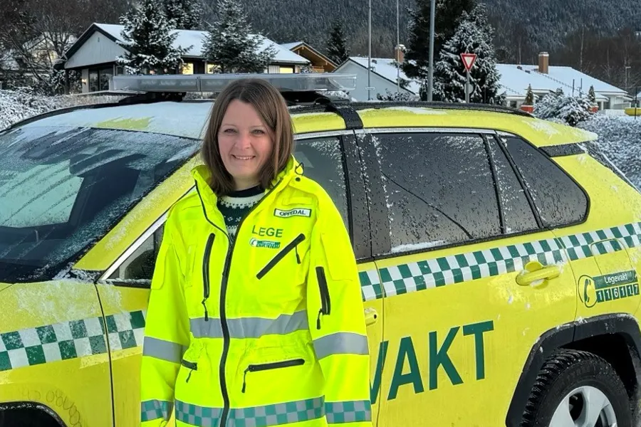 En person i gul jakke som står ved siden av en gul bil