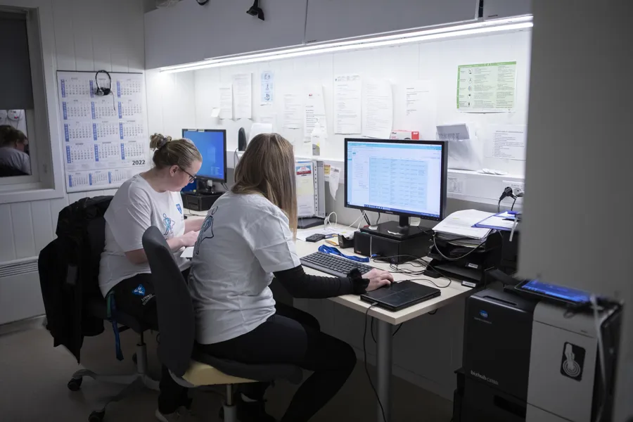 En mann og en kvinne som sitter ved et skrivebord med datamaskiner