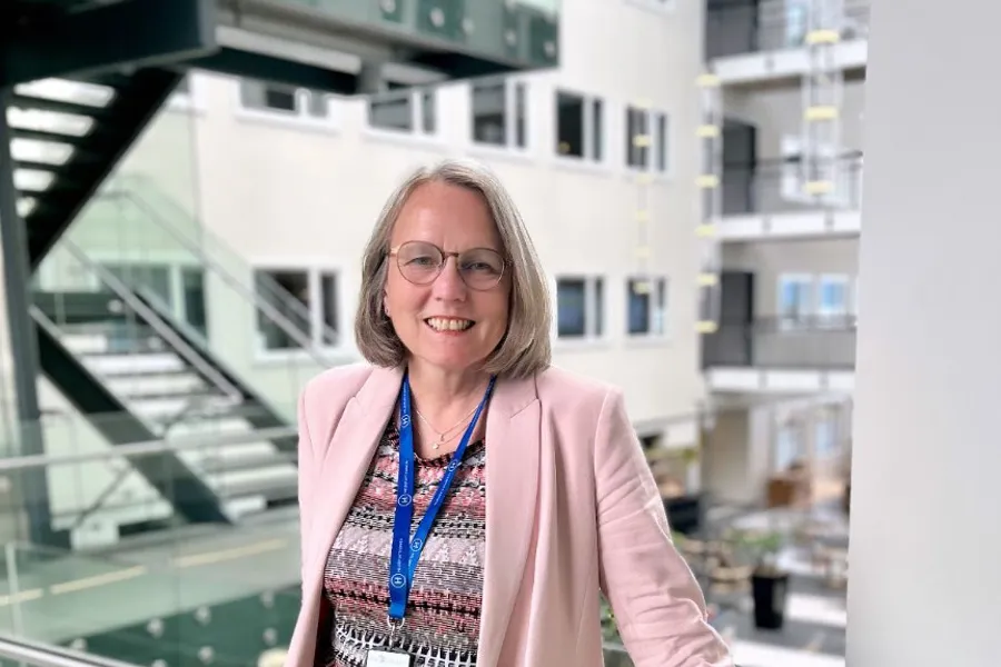 Bilde av Siri Berg, administrerende direktør i Helseplattformen. Hun smiler og er avbildet med lys bakgrunn og har på seg lyse farger.
