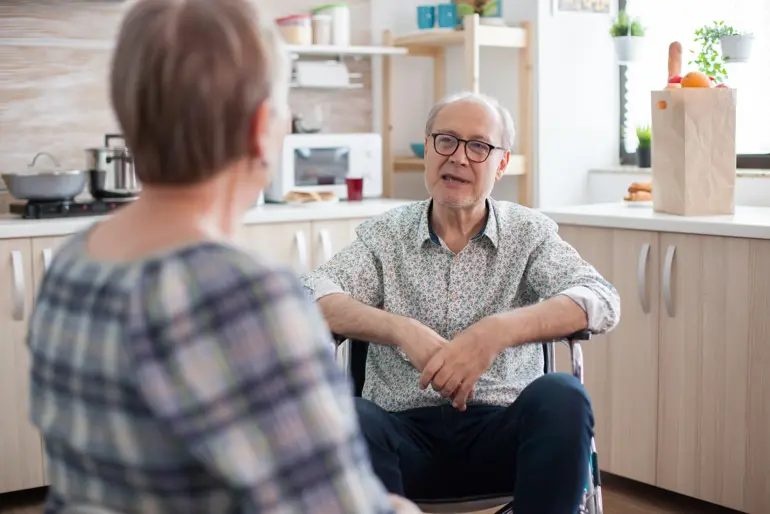 Bilde av en mann med briller som snakker med en kvinne