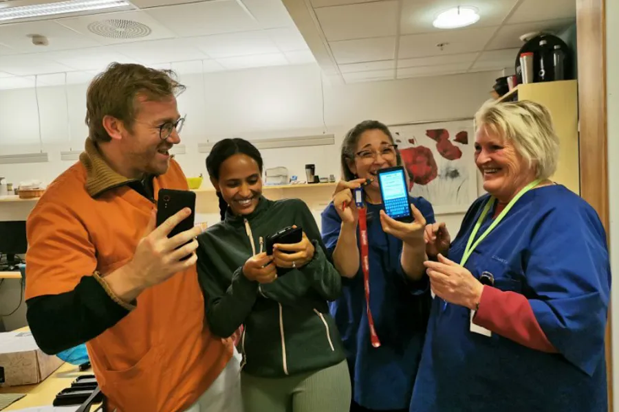 En gruppe mennesker som ser på telefonene sine