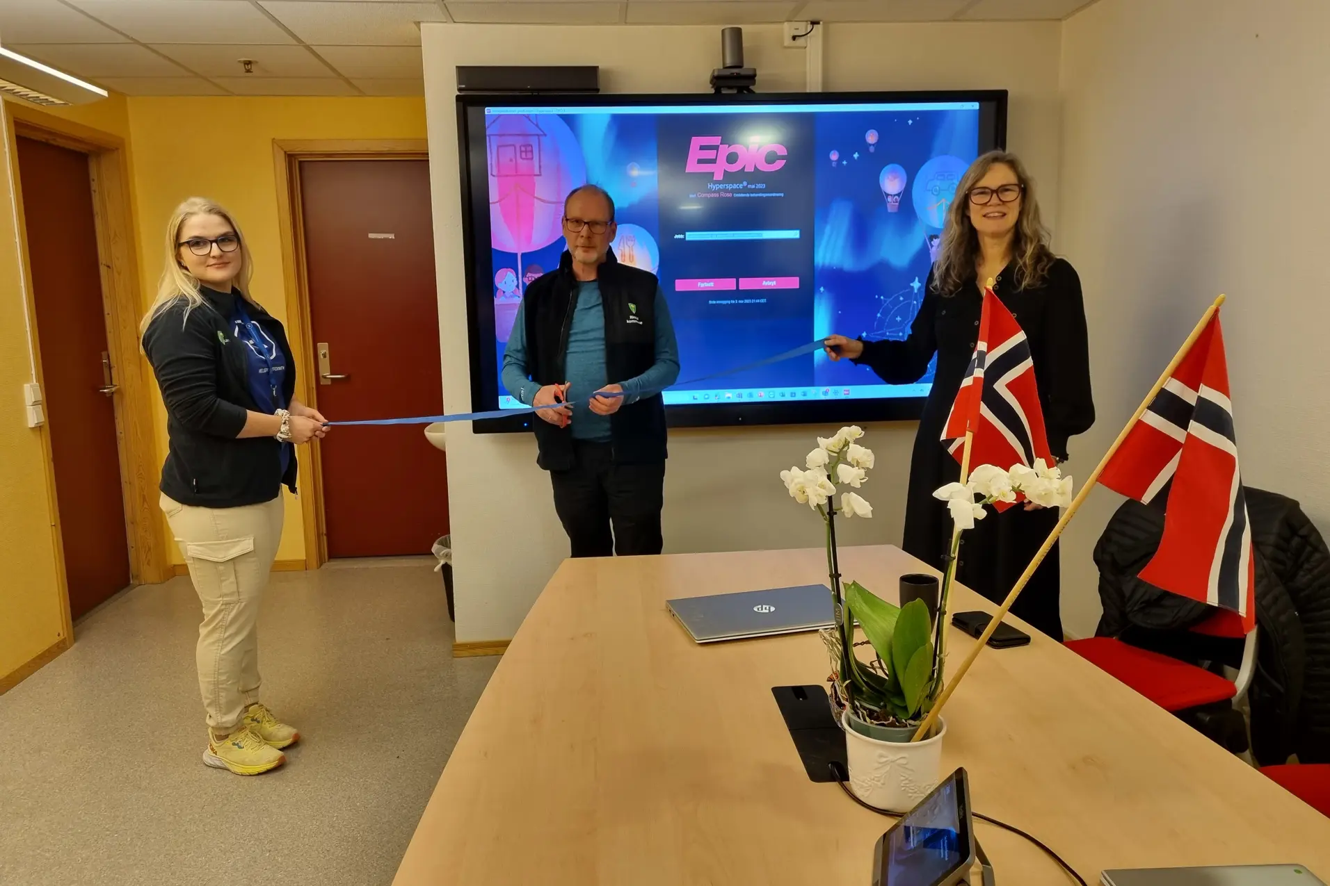 En gruppe mennesker som står foran en skjerm