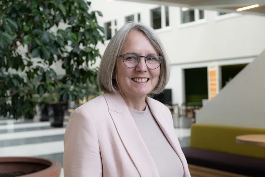 Siri Beate Berg smiler i en lys hall.