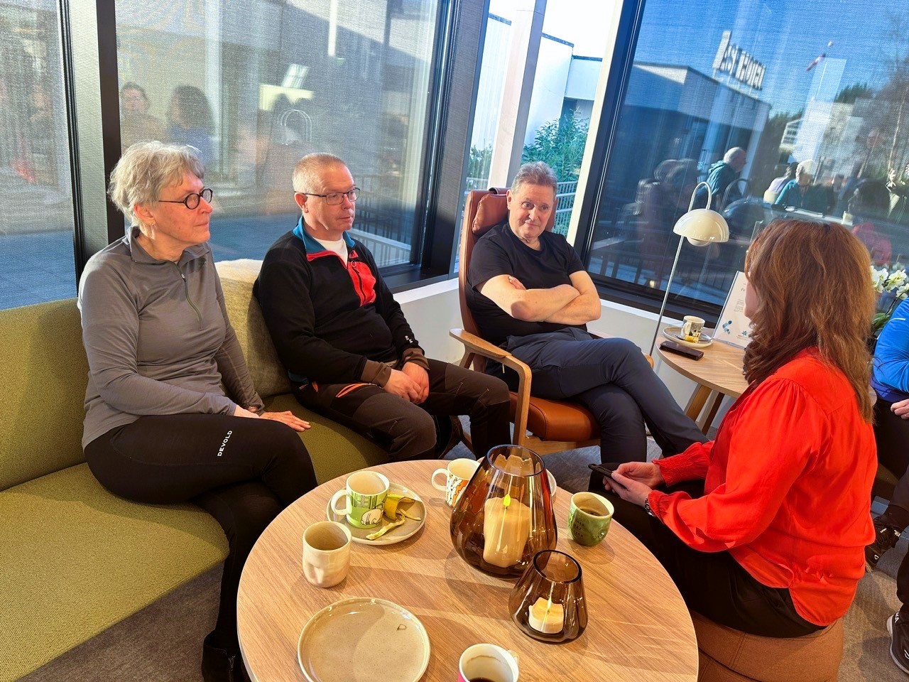 Kari Asker sitter sammen med andre treningsdeltakere ved Pusterommet i Ålesund.