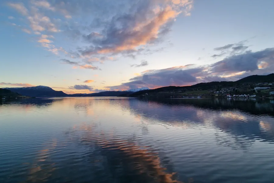 En vannmasse med fjell i bakgrunnen