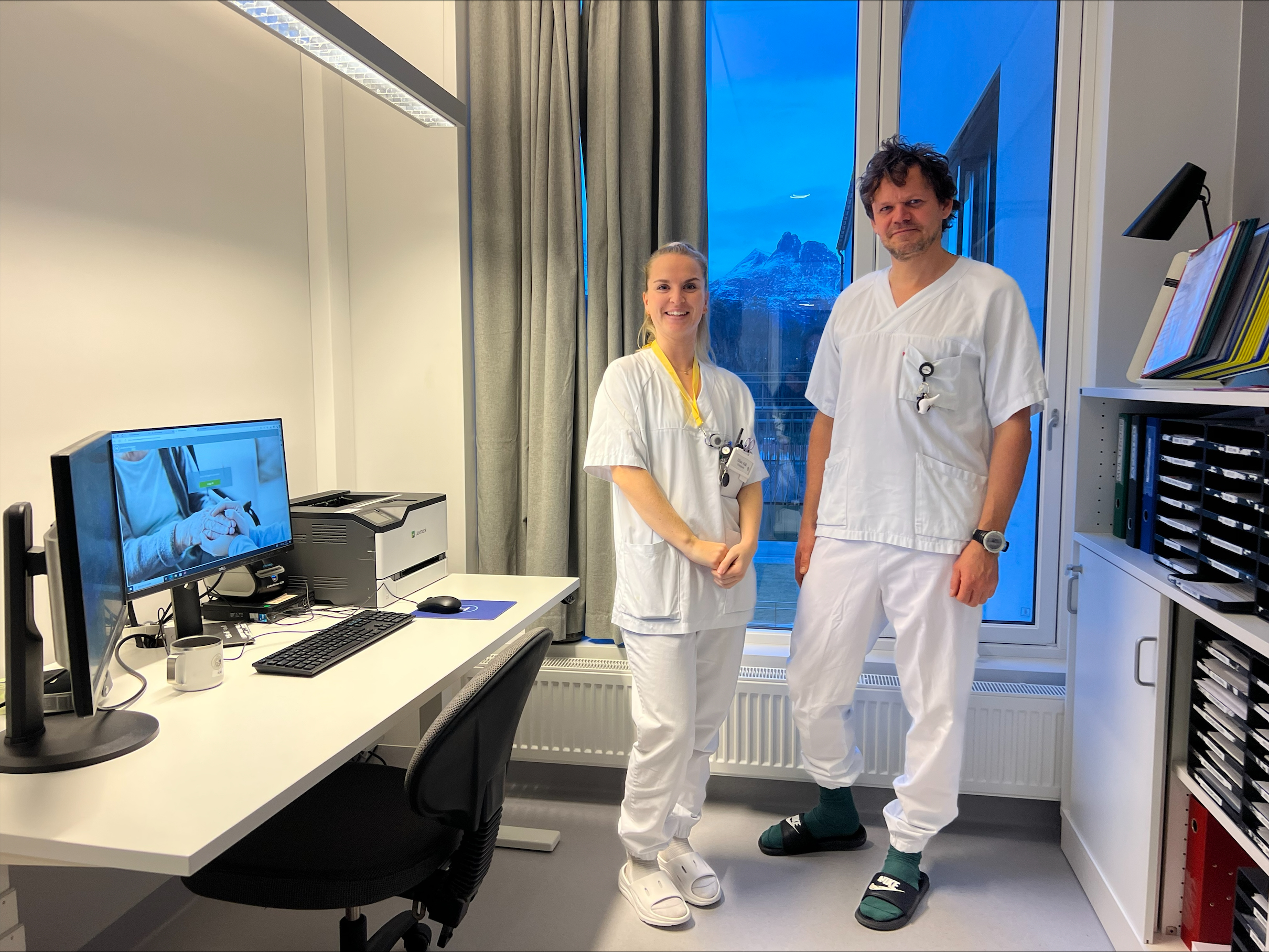Sykepleier Elise Aak og tilsynslege Erling Thompson Rosenstrøm står foran en pc