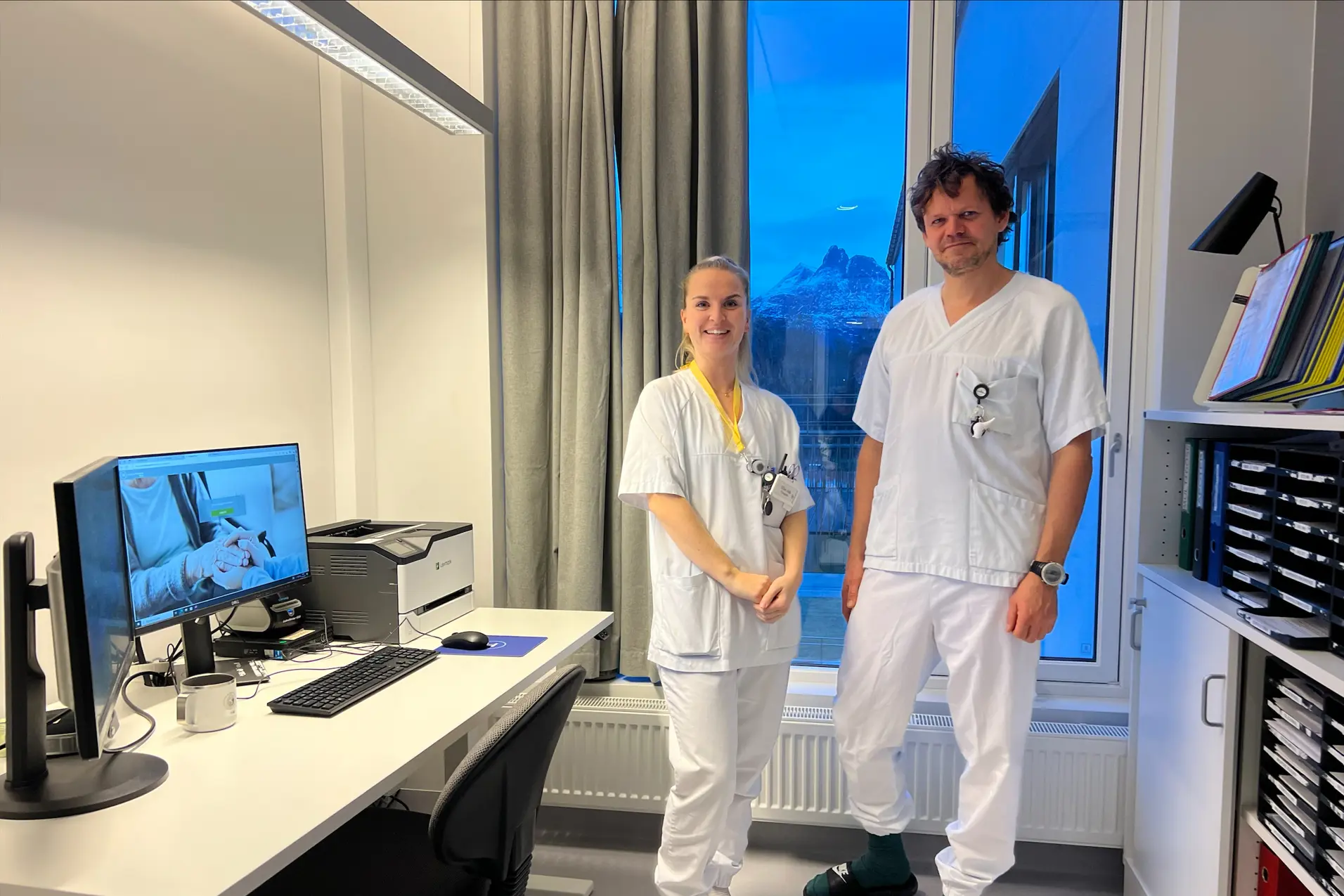 Sykepleier Elise Aak og tilsynslege Erling Thompson Rosenstrøm står foran en pc