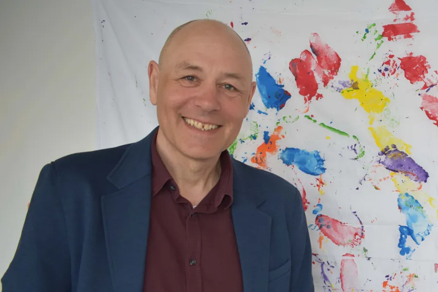 En mann som smiler foran et kart